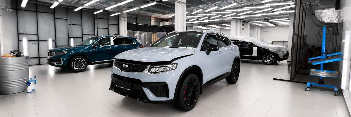 Светлый зал кузовного цеха с автомобилями на подготовке